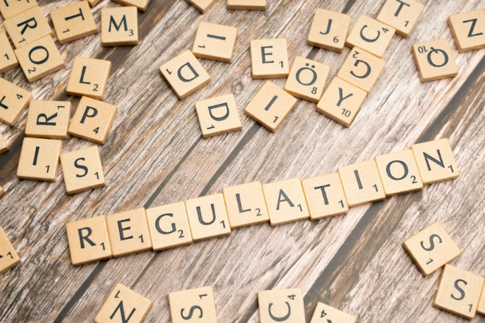 scrabble tiles spelling out the word regulation on a wooden surface
